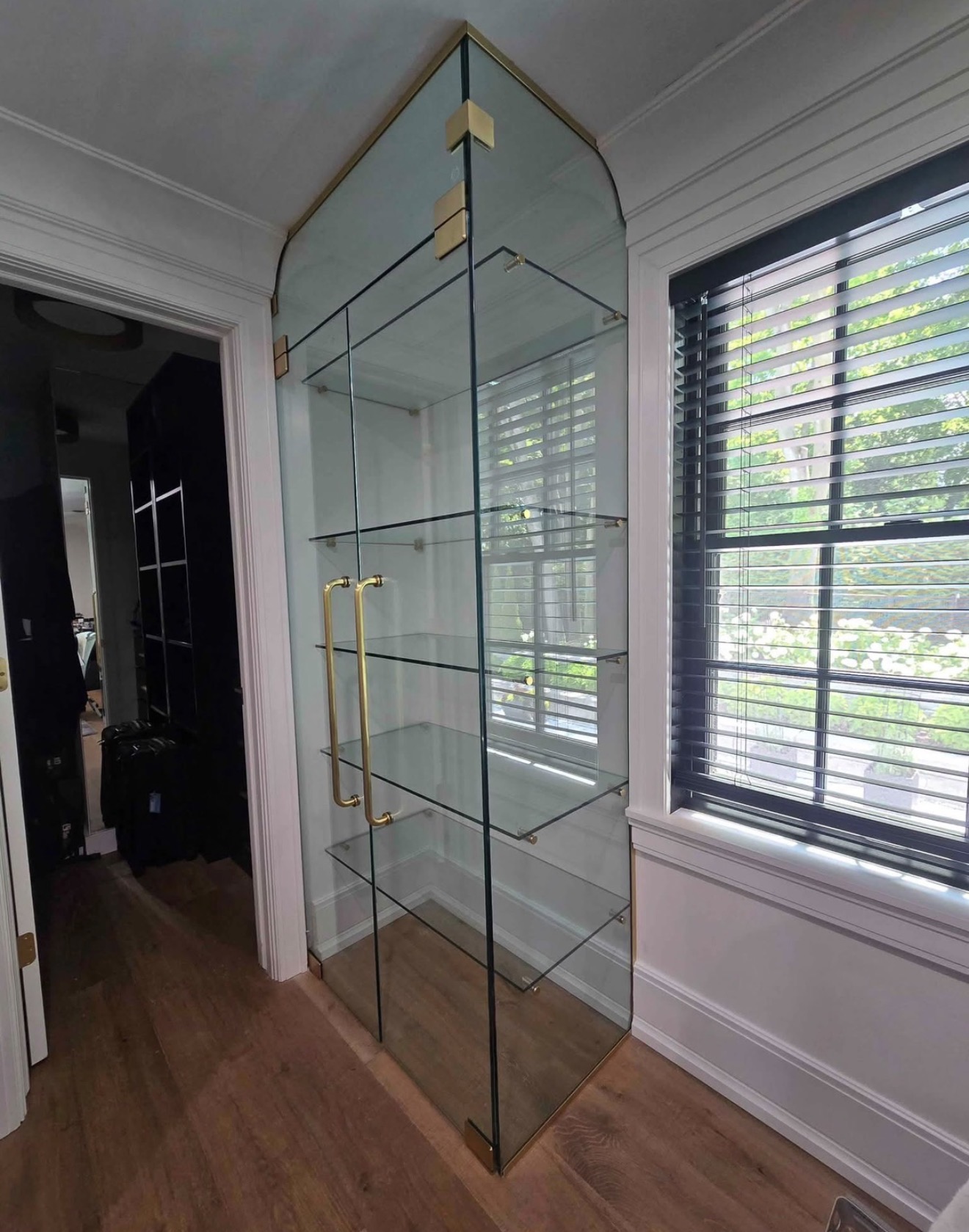 Custom curved glass display cabinet with brass hardware