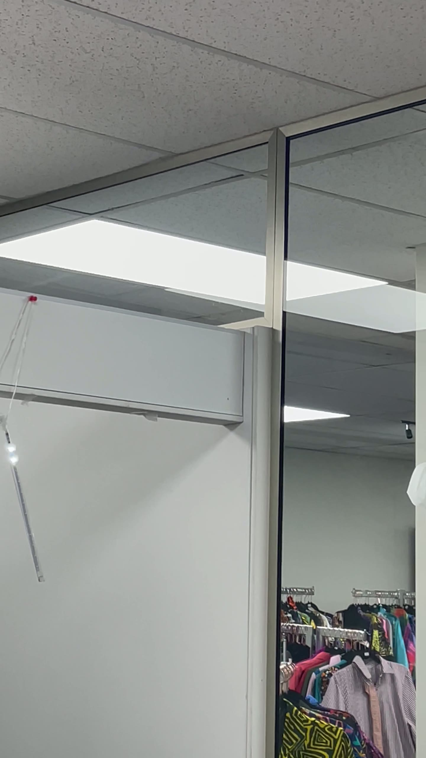 Full-height glass partition enclosing a colourful retail interior