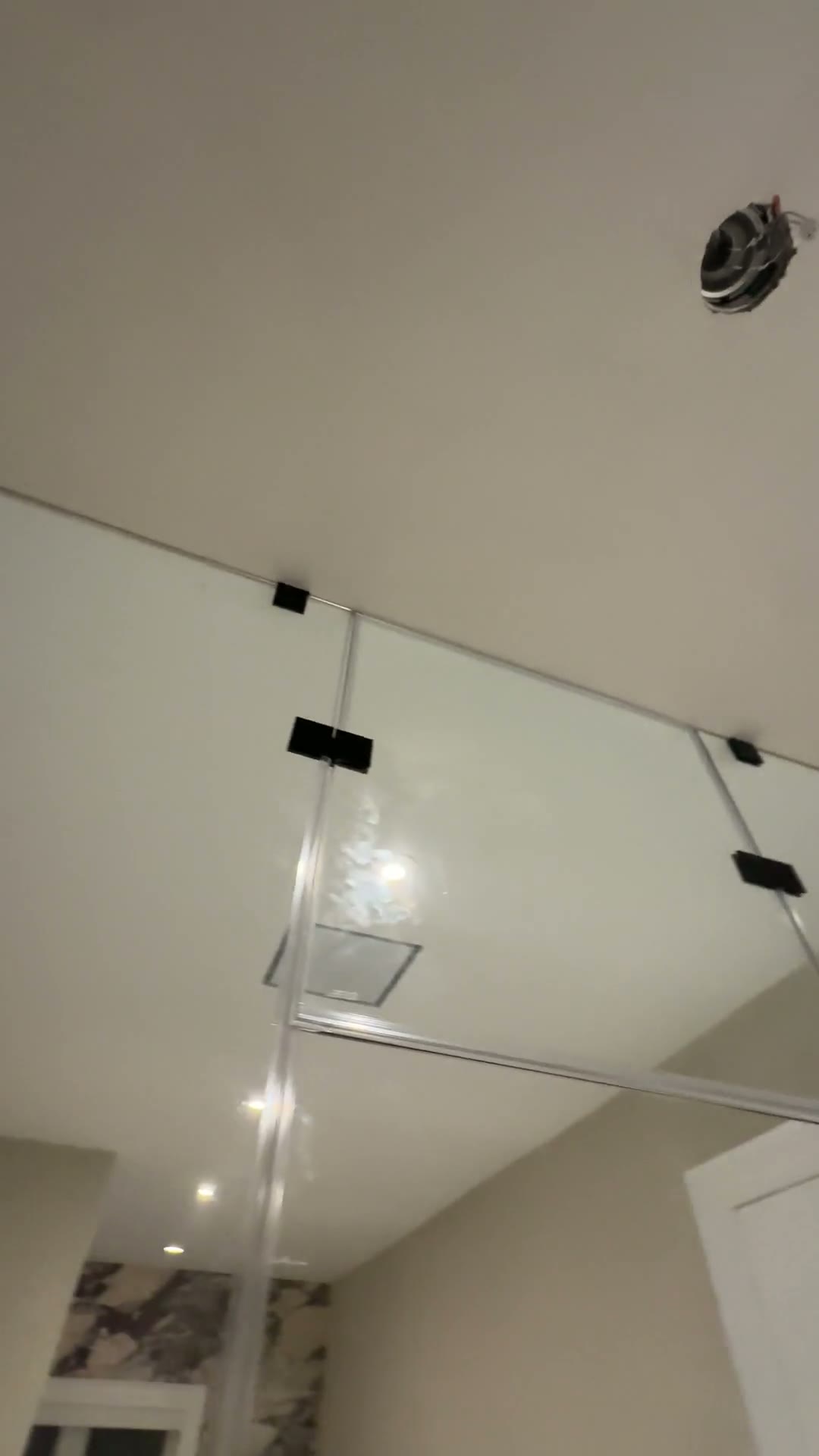 Custom frameless glass shower enclosure fitted precisely beneath a sloped ceiling