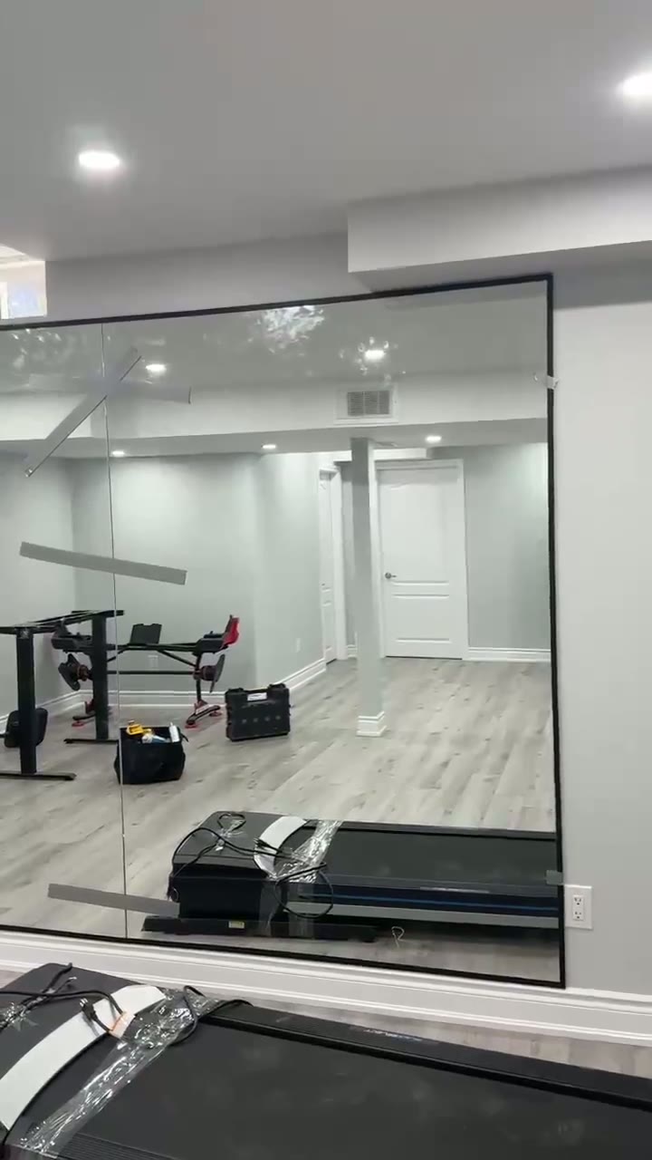 Black-framed glass wall enclosing a lower-level home gym
