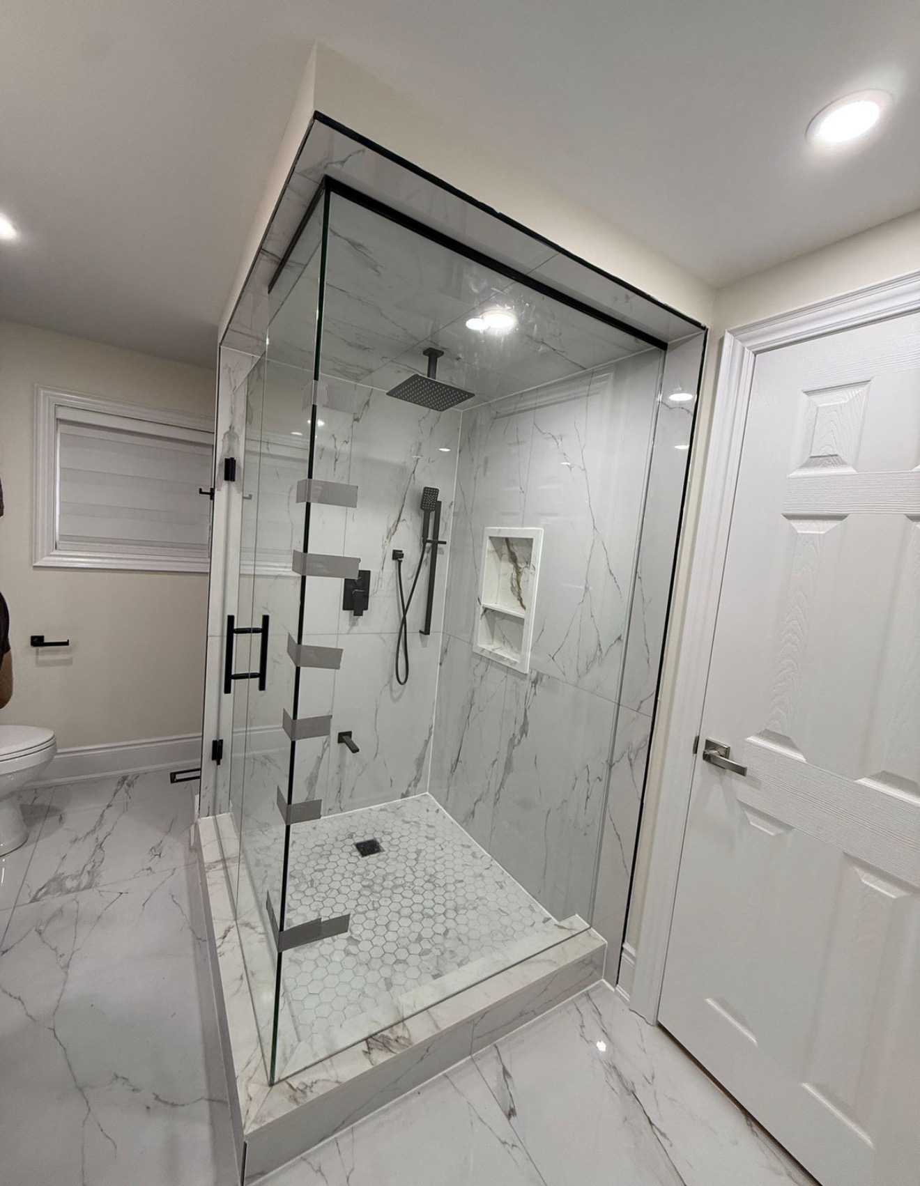 Corner glass shower installation with black header