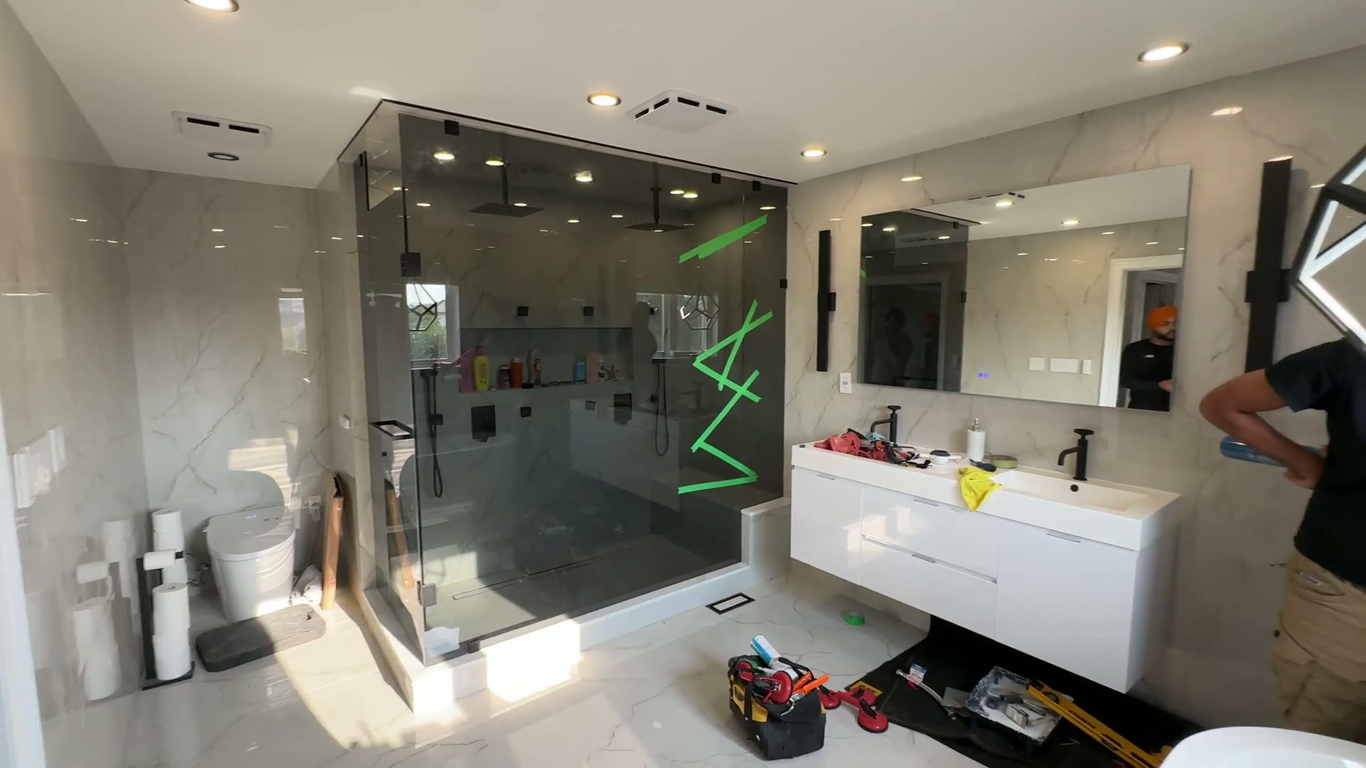 Full bathroom view of the frameless steam shower and floating vanity