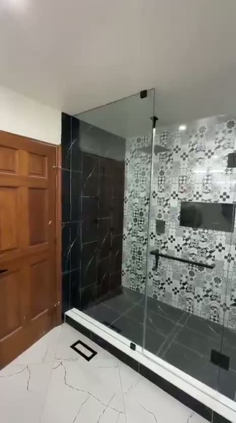 Frameless walk-in glass shower with patterned tile feature wall