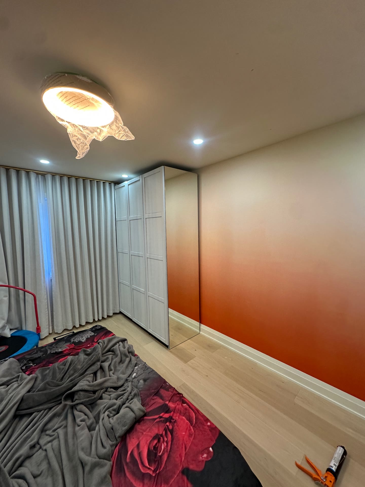 Wide view of the mirrored wardrobe installation and reflected feature wall